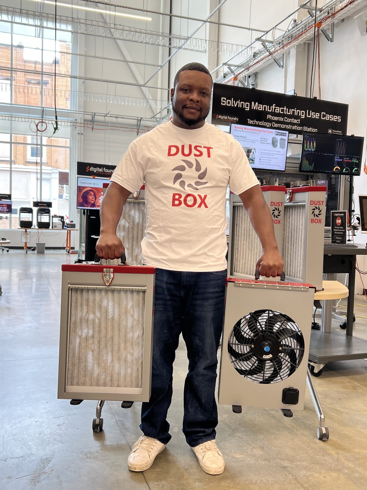 Dust Box creator Sam Burton holding two Dust Box units